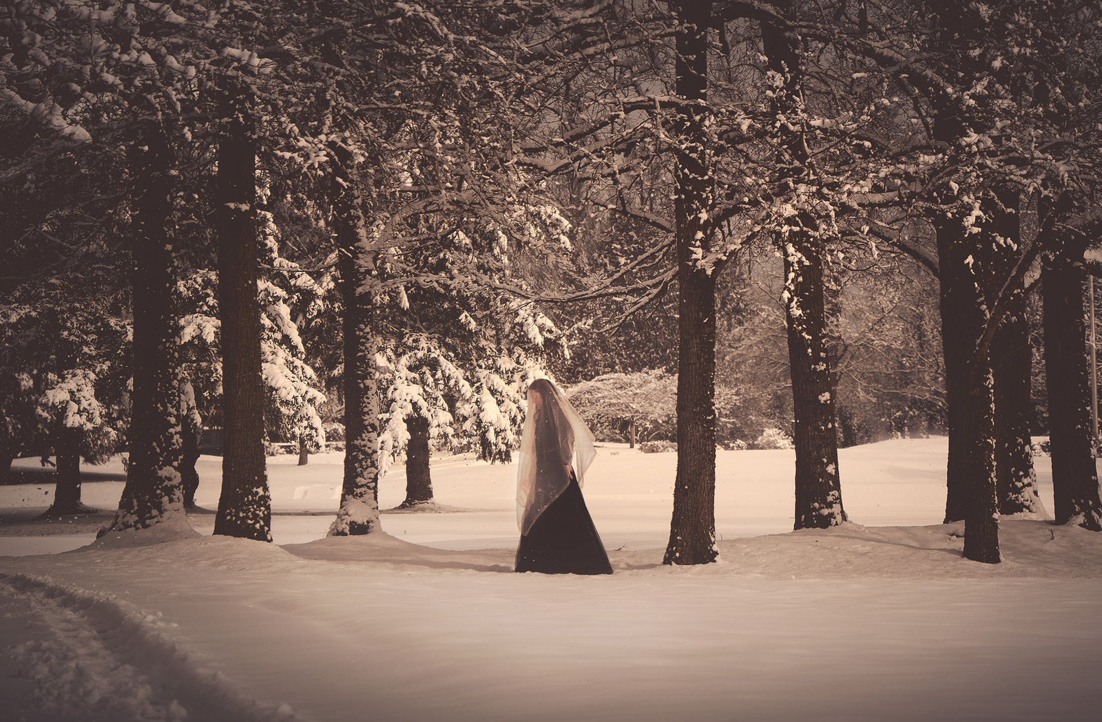 Self-portrait-photography-session-in-the-snow-seating-under-the-trees