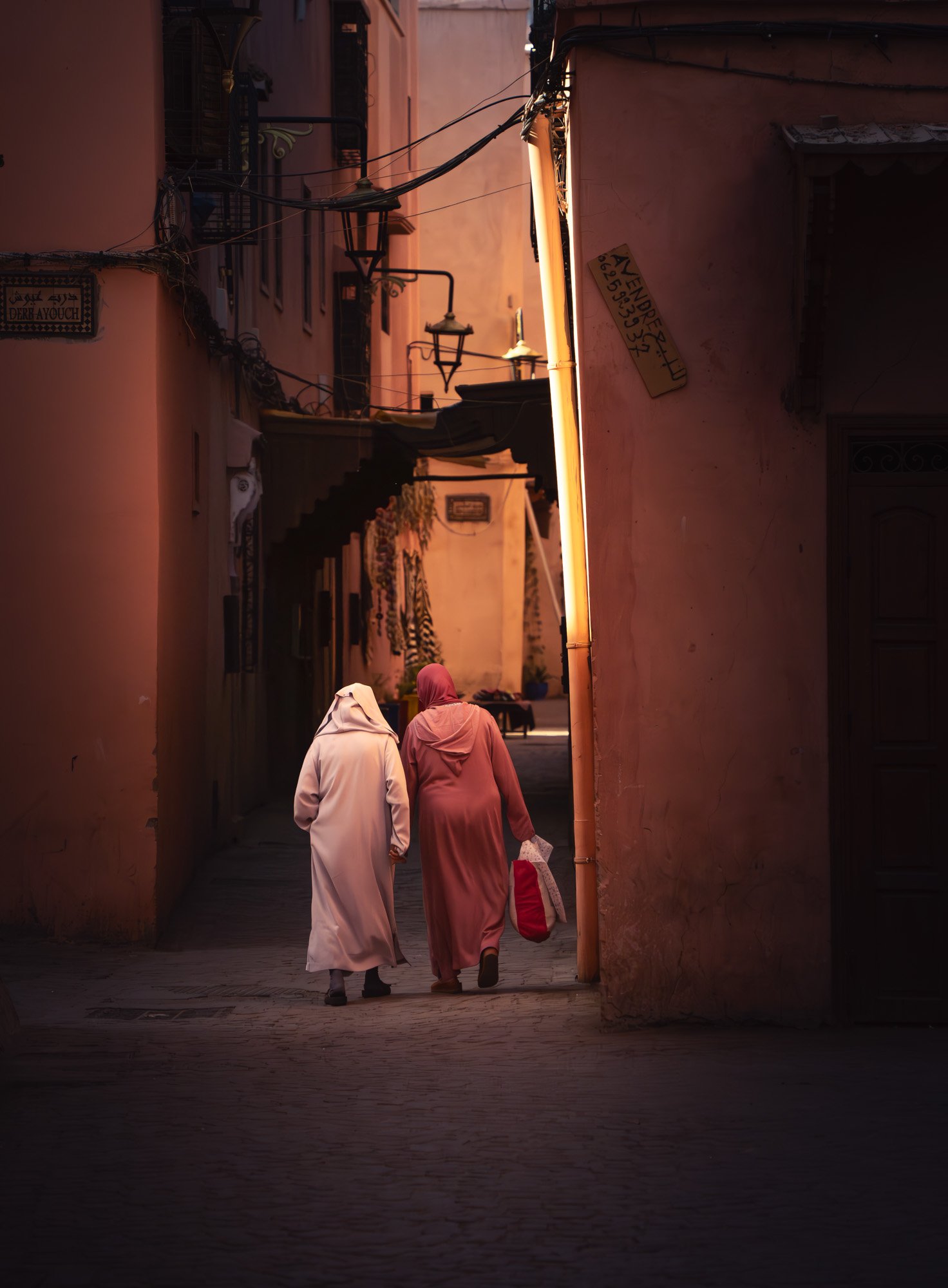 street portrait in medina in Marrakesh two women walking in the market